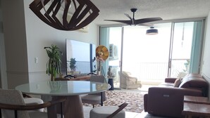 Un'ampia zona giorno con tavolo e sedie da pranzo, divano e ventilatore a soffitto.