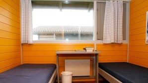 A small, single-room dormitory with two beds, a desk, and a window. - 6 Person Holiday Home on a Holiday Park in Hanstholm (Hanstholm)