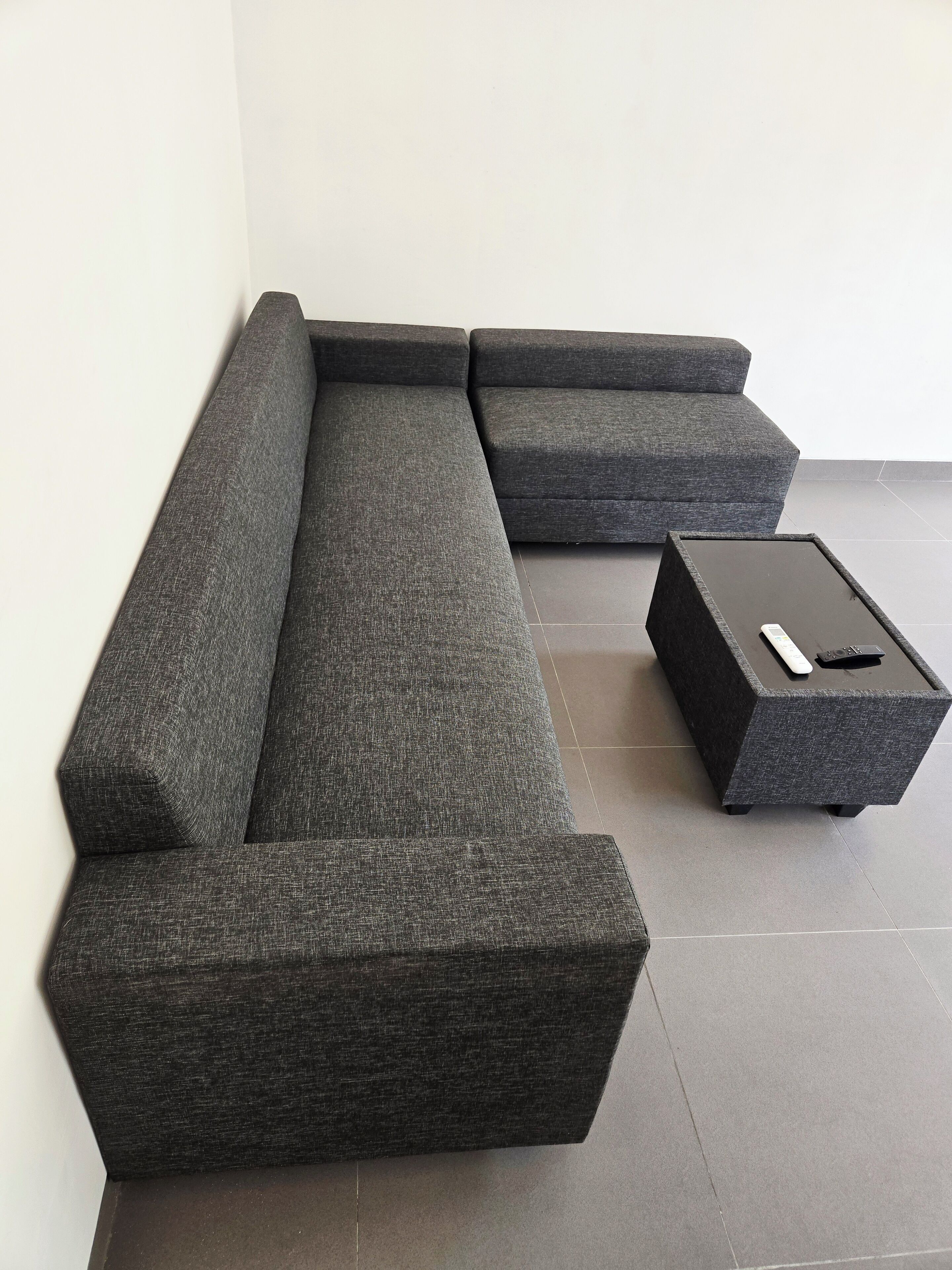 Un canapé modulable assorti d’un pouf et d’une petite table d’appoint.