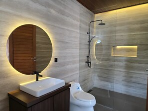 Een aparte badkuip en douche, een bubbelbad, een regendouche