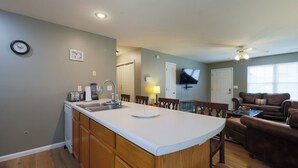A kitchen with a central island, wooden cabinets, a dishwasher, and a dining area with chairs. - Quiet, Family Friendly 3/2 Home (Columbia)