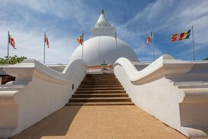 Un templo blanco con una cúpula central y una escalera que lleva hacia él.
