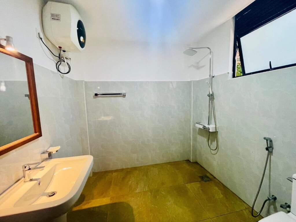 A bathroom with a sink, mirror, shower, and a ceiling fan.
