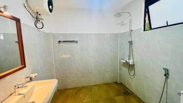 A bathroom with a sink, mirror, shower, and a ceiling fan.