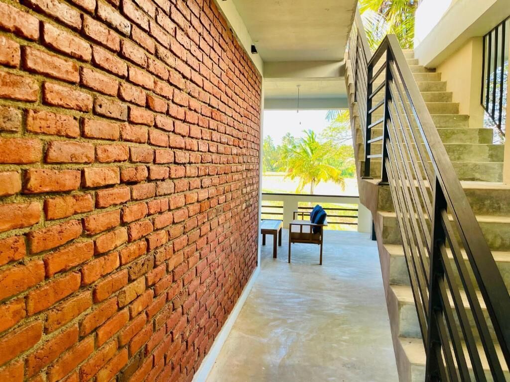 A brick wall, a staircase, and a view of palm trees.
