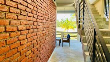 A brick wall, a staircase, and a view of palm trees.