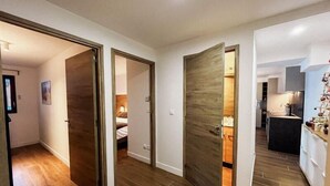 A modern apartment with wooden flooring, a kitchen with a sink and countertop, and a bedroom with a bed and nightstand. - Ground floor, terrace, tv, 193m², Vars (Vars)