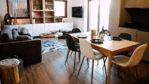 A modern living room with a wooden dining table, comfortable seating, and built-in shelving. - Ground floor, terrace, tv, 193m², Vars (Vars)