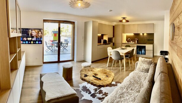 A modern living room with a wooden floor, a round coffee table, a sofa, and a dining area with a table and chairs. - Ground floor, terrace, tv, 193m², Vars (Vars)