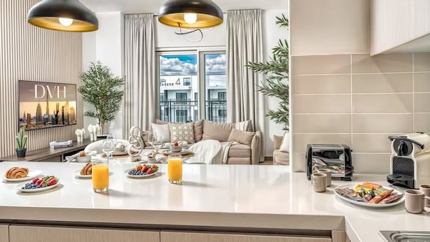 Ett modernt kök med en central köksö, en matplats med soffa och utsikt över stadsbilden.