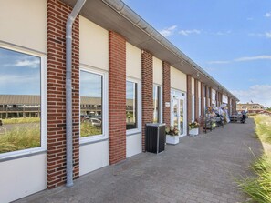 Een rij bakstenen gebouwen met grote ramen en een verharde looppad.