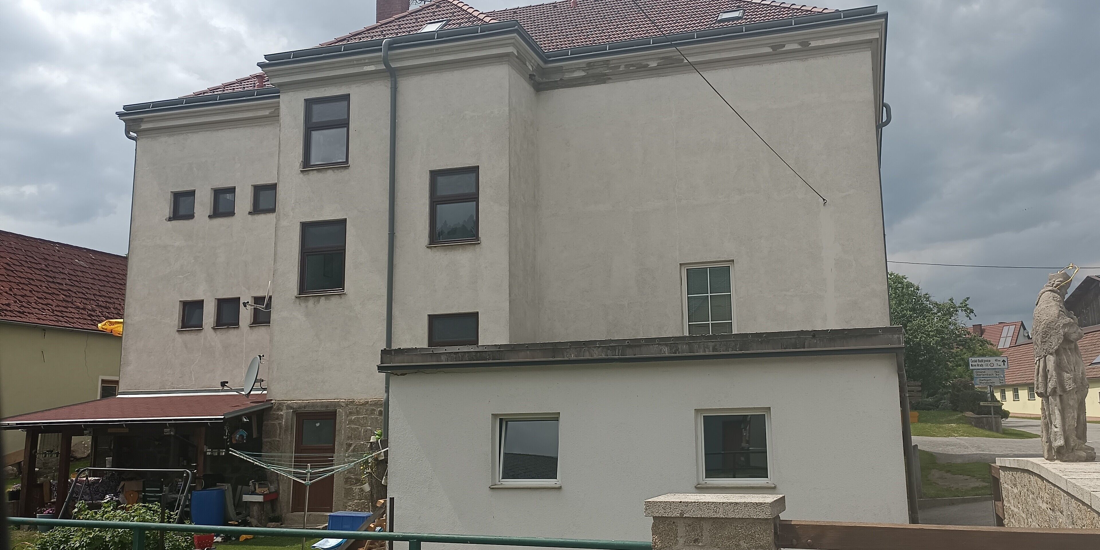 A two-story building with multiple windows and a satellite dish.