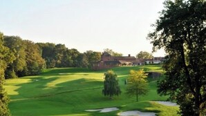 A golf course with a clubhouse in the background.