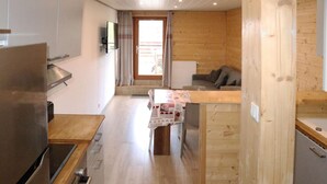 Een knus keuken met een houten aanrecht, een ingebouwde oven en een eethoek met een tafel gedekt voor twee personen.