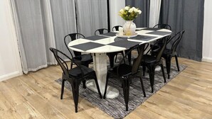 Ein Essbereich mit einem runden Tisch, schwarzen Stühlen und einem Blumenstrauß.