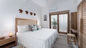 Une chambre à coucher avec un lit, une table de chevet, une lampe et une armoire en bois.