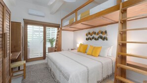 A bedroom with a bunk bed, a bedside table, a lamp, a potted plant, and a wall with hanging tassels. - Oceanfront 2-bedroom luxury at La Escondida - Relax & Enjoy! (Puerto Escondido)