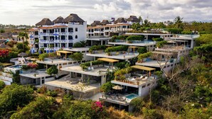 A resort with multiple buildings, each featuring balconies, outdoor seating, and a pool. - Oceanfront 2-bedroom luxury at La Escondida - Relax & Enjoy! (Puerto Escondido)