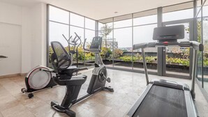 A modern home gym with a treadmill, stationary bike, elliptical, and a rowing machine. - Cozy & beautiful place in downtown in CDMX D6 (Ciudad de México)