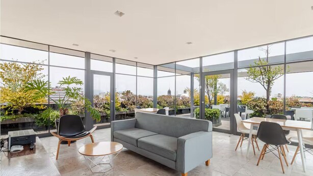 A spacious indoor area with large windows, a grey sofa, a round table, and a dining table with chairs. - Cozy & beautiful place in downtown in CDMX D6 (Ciudad de México)