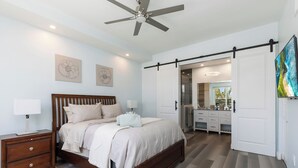 A bedroom with a bed, nightstand, and a ceiling fan.