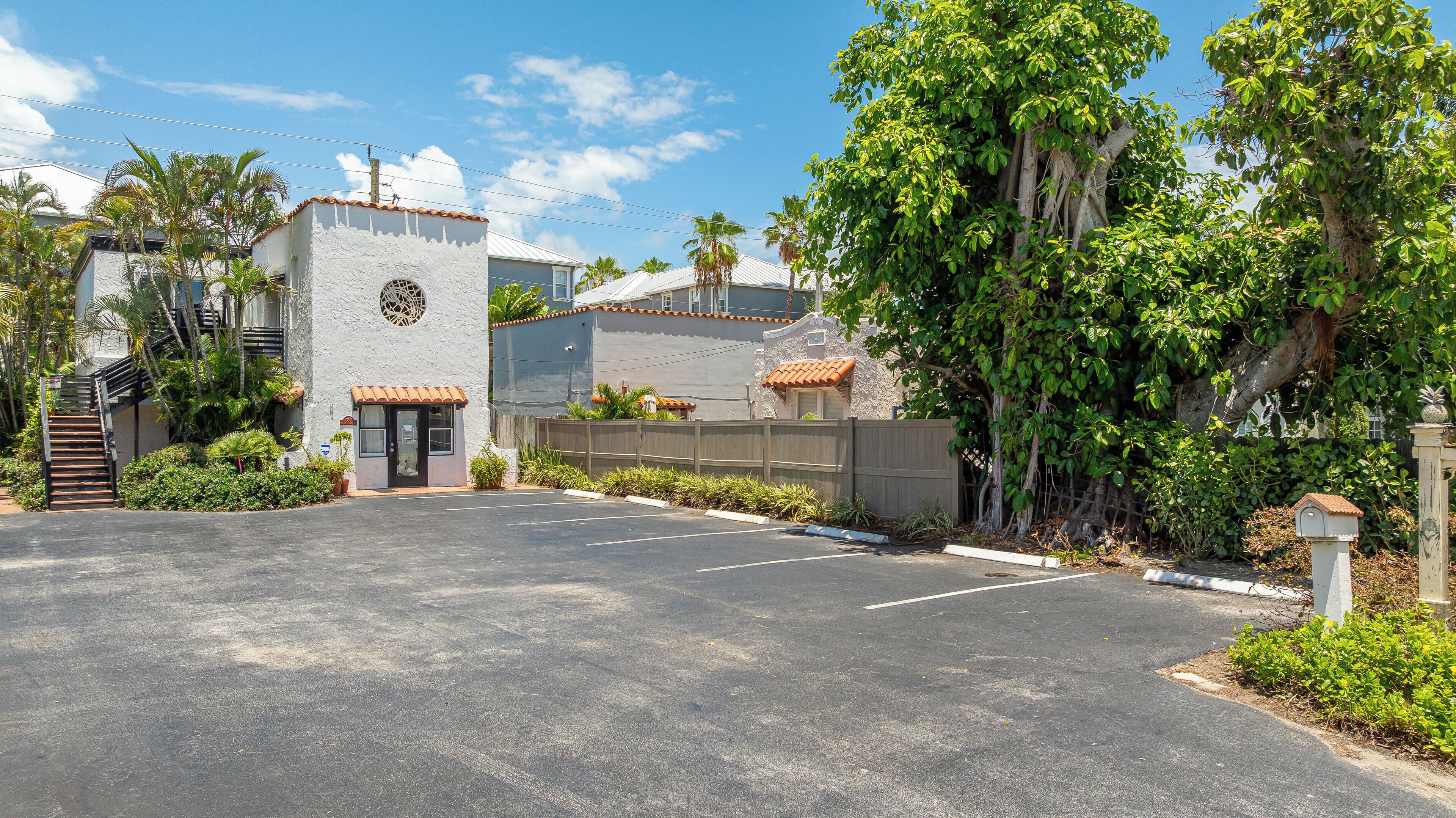 A parking lot with a building featuring a stone facade and a tiled roof.