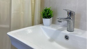 A bathroom sink with a modern faucet, a potted plant, and a shower curtain. - Lovely 5-bedroom house with WiFi in charming Dilijan (Dilijan)