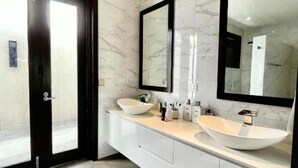 A modern bathroom with two sinks, large mirrors, and a glass shower door. - Four Bedroom Riverfront Villa 62 (Nadi)
