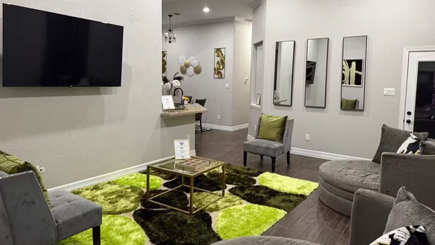 Een moderne woonkamer met een flatscreen televisie, een salontafel en een hoekbank.