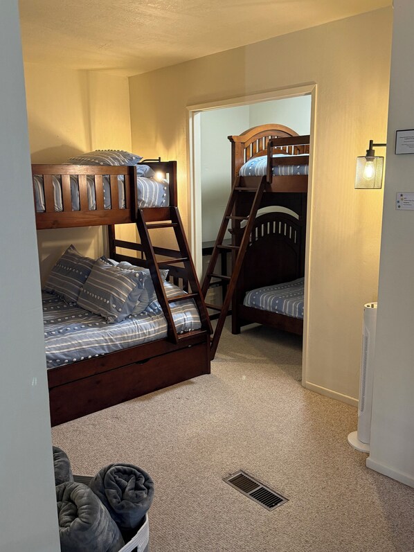 A room with two bunk beds, a radiator, and a light fixture.