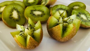 A plate with sliced kiwi halves arranged on a white plate. - Hotel Village Penareia (Tarrafal)