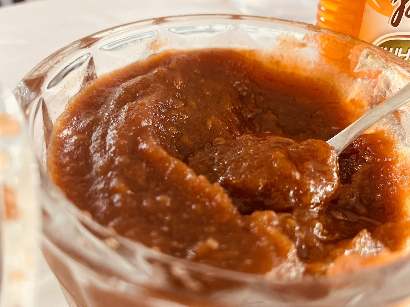 Eine Schüssel mit dicker, dunkelbrauner Soße und einem Löffel.