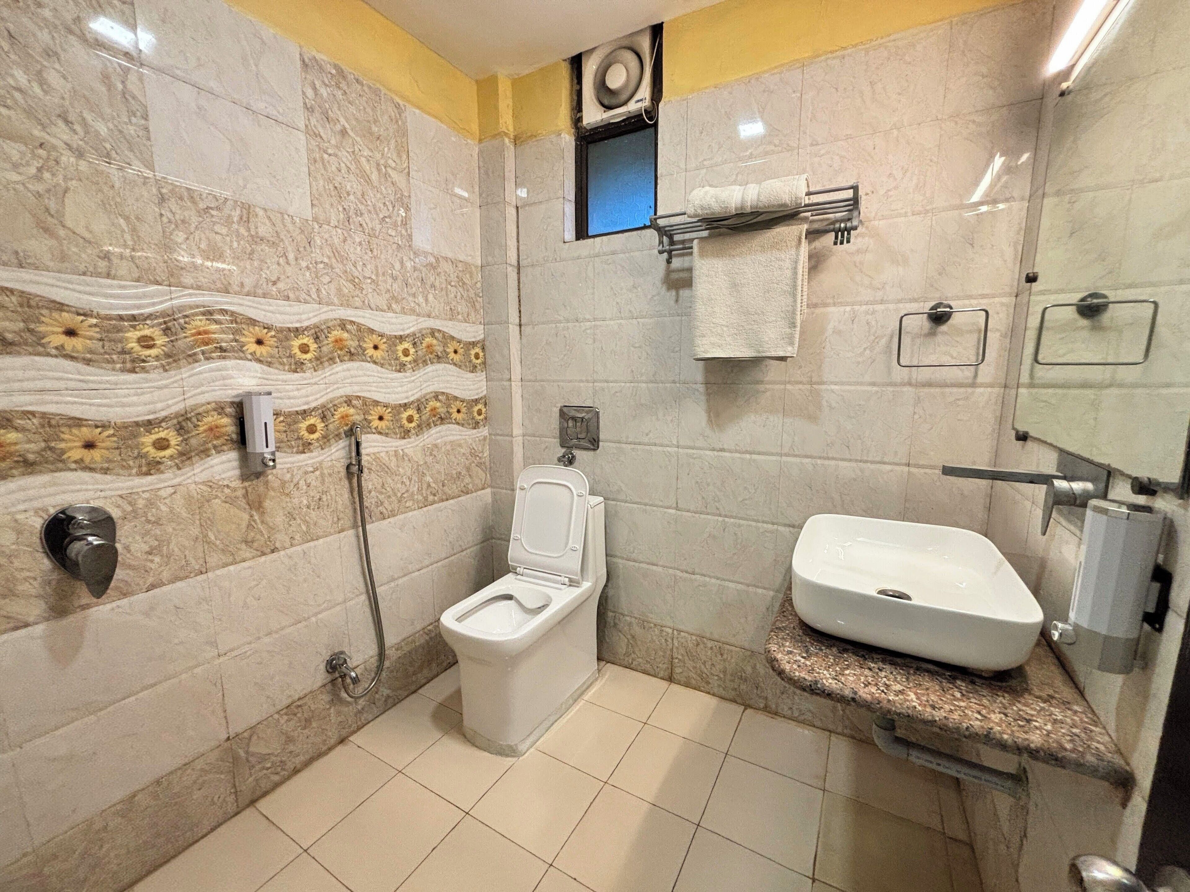 A bathroom with a toilet, bidet, and sink.