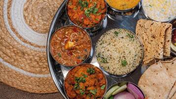 A traditional Indian meal with various dishes and flatbreads on a metal tray.