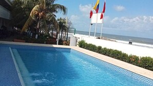 Piscina com vista para o oceano e bandeiras.
