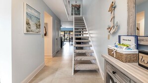 Ein modernes Interieur mit einer Treppe, einem Gästebuch und einem Strandgemälde.