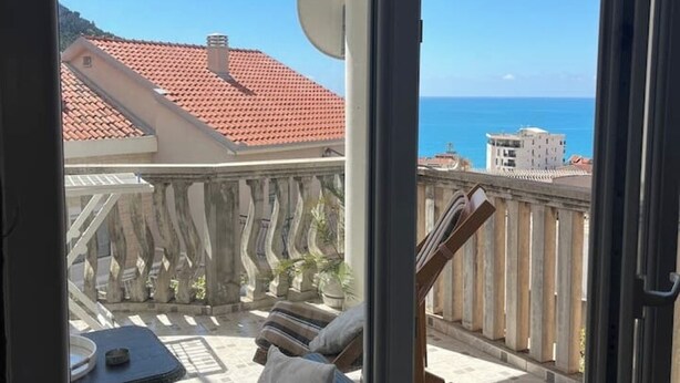 Un balcon avec vue sur la mer et les bâtiments.