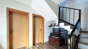 Ein modernes Interieur mit Holztüren, einer Treppe und einer kleinen Holzkiste.