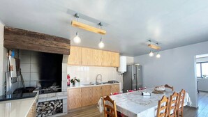 Eine moderne Küche mit Holzausstattung, einer zentralen Kochinsel und Pendelleuchten.