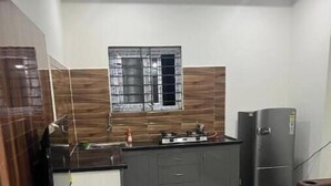 Une cuisine moderne équipée d’une cuisinière intégrée, d’un réfrigérateur et d’une fenêtre située au-dessus de l’évier.