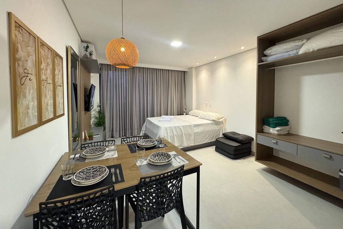 A modern bedroom with a bed, bedside table, and a wardrobe.