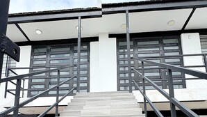Eine Treppe führt zu einem Gebäude im modernen Stil, mit Metallgeländern und mehreren Stufen.