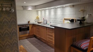 Una cucina moderna con piastrelle bianche a metro, mobili in legno e un piano di lavoro nero.
