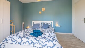 A bedroom with a bed, a bedside table, a hanging light fixture, and a wall-mounted shelf. - Le Bosquet - Appt Climatisé, Proche Plage (Sainte-Maxime)