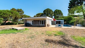 Una casa moderna con fachada de piedra, piscina y césped bien cuidado.