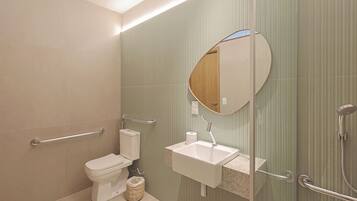 Un baño moderno con inodoro, lavamanos y ducha.