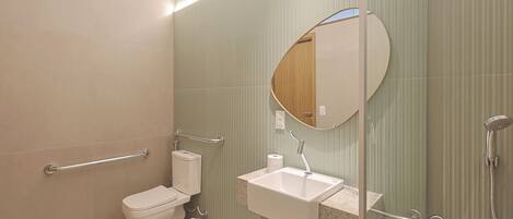 Un baño moderno con inodoro, lavamanos y ducha.
