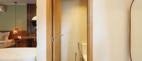 A bathroom with a bathtub, shower, and toilet.