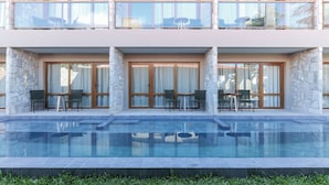 Um hotel moderno com piscina, fachada de pedra e áreas de estar ao ar livre.