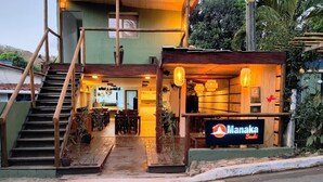Un restaurant avec une enseigne indiquant « Manaka Sushi » et un escalier menant à l’entrée.
